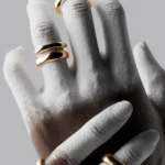 Creative hand modeling with gold rings on painted white hands