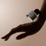 Minimalist hand modeling with perfume bottle on extended hand