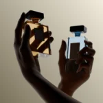 Hand modeling shot with two luxury perfume bottles on a dark background