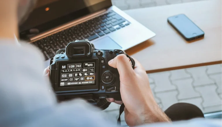 Photographer adjusting DSLR camera settings on the rear LCD screen in a studio environment